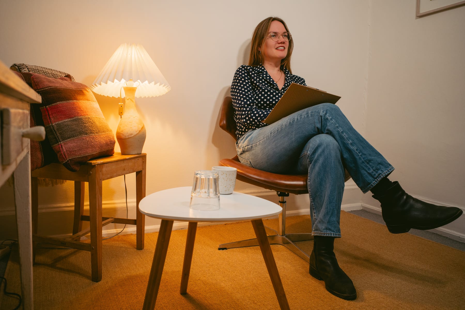 Anna Langfred sidder i en lædestol i klinikken med en blok i hånden